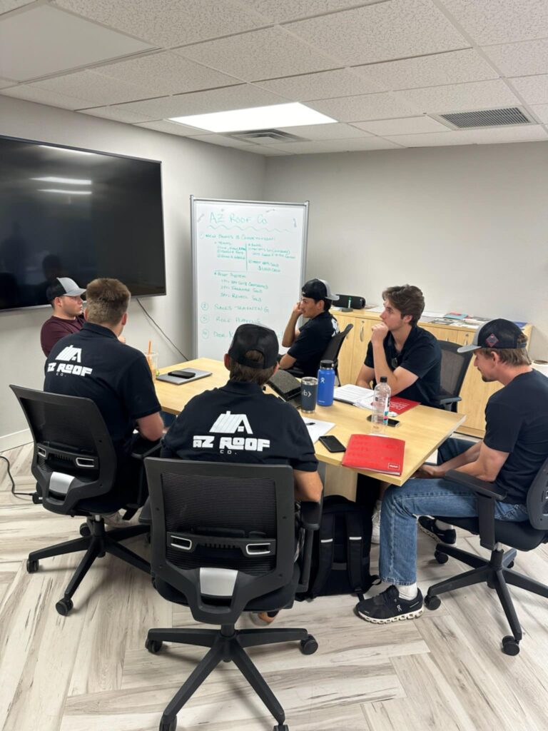 A group of commercial roofing contractors discussing a project in front of a commercial building.
