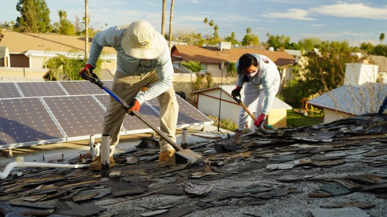Roofers removing old roofing material